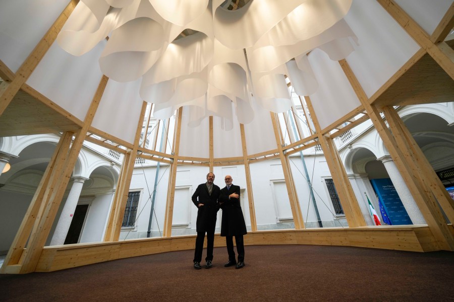 Grande Brera Museum director, Angelo Crespi, right, poses flanked by designer Mario Cucinella inside a wooden temple, at Palazzo Citterio Museum in Milan, Italy, Saturday Dec. 7, 2024. (AP Photo/Luca Bruno)